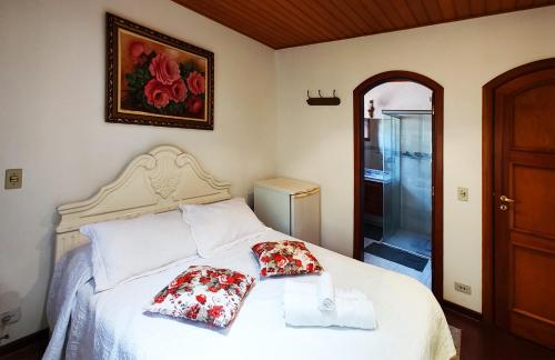 a bedroom with a bed with two pillows on it at Pousada Casa dos Sonhos in Campos do Jordão