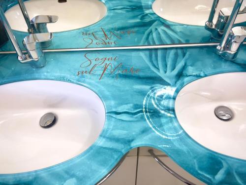 a bathroom with two sinks and signatures on the counter at SOGNI sul MARE-5 TERRE JRE in La Spezia