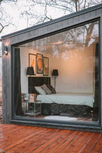 a room with a bed inside of a glass window at Domek Hrabiny nr 3 in Rozkochów