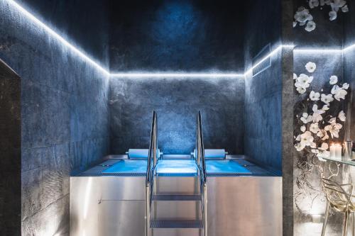 a bathroom with a blue tub with a ladder at Royal Apartmány in Dobříš