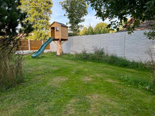 a backyard with a bird house and a slide at Meadows House Lomnice in Lomnice