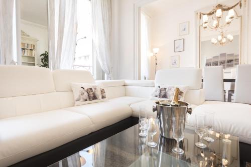 a white living room with a white couch and a glass table at Apartments Center Colmar in Colmar