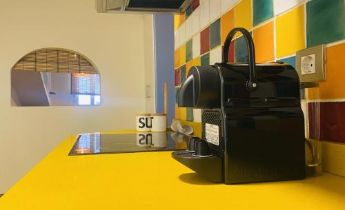 a coffee machine sitting on a yellow counter in a room at Jositown in Santander