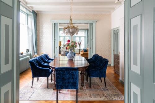 uma sala de jantar com uma mesa de madeira e cadeiras azuis em De Jonge Barones em Beetsterzwaag