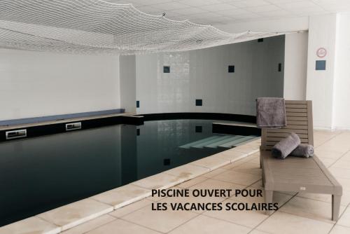 a swimming pool with a chair in front of a swimming pool at Appartement moderne central avec piscine, garage privé et terrasse sud in Uzès