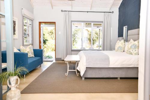 a bedroom with a bed and a blue couch at Gowan Valley Guest Farm in Balgowan