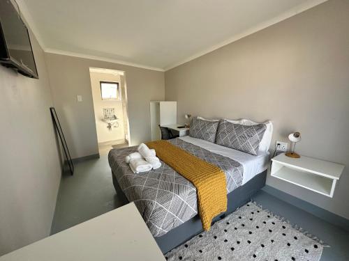 - une petite chambre avec un lit et des serviettes dans l'établissement 19 on Gordon, à East London