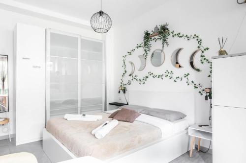 una camera bianca con un letto con due asciugamani di [Eden House SanSiro-Duomo] Netflix & Design a Milano