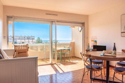 - un salon avec une table et une vue sur l'océan dans l'établissement Appartement moderne vue mer à Port-la-Nouvelle — 42 m², à Port-la-Nouvelle
