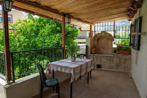 a patio with a table and chairs on a balcony at House Rachati in Zaros