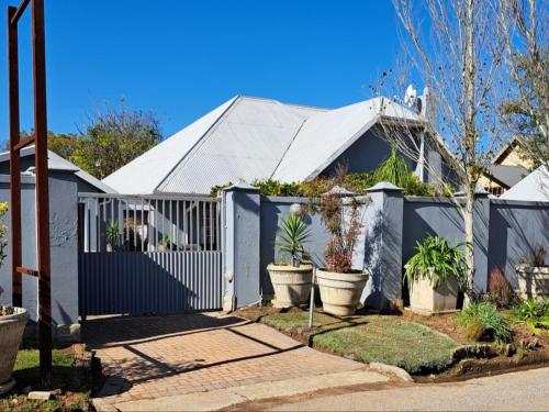 a white fence in front of a house with plants at No. Forty2 on President in Parys