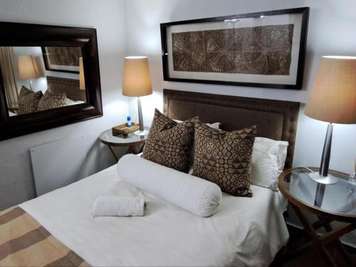 a bedroom with a bed with pillows and a mirror at No. Forty2 on President in Parys