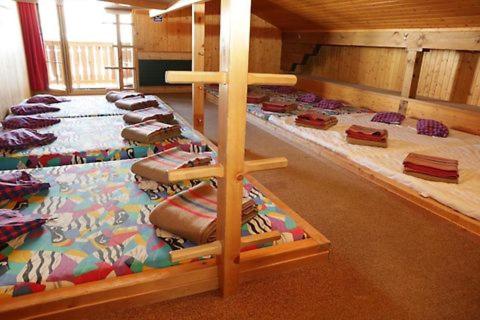 eine Gruppe von Betten in einem Zimmer mit einem Kreuz in der Unterkunft Sonnenberg Dormitories in Mürren