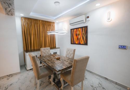 Gerdette Luxury Apartment في لاغوس: غرفة طعام مع طاولة وكراسي