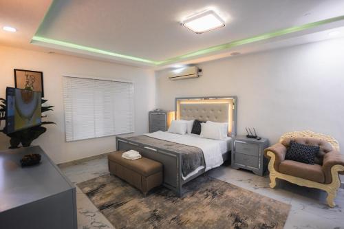 Gerdette Luxury Apartment في لاغوس: غرفة نوم بسرير كبير وكرسي