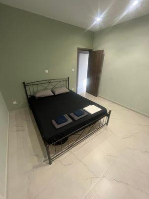 ein Schlafzimmer mit einem schwarzen Bett in einem Zimmer in der Unterkunft Stratos’ Home in Malakóndas