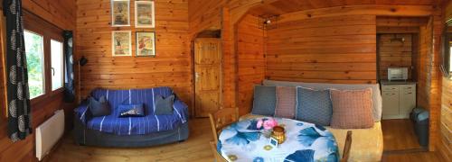 Sala de estar de una cabaña de madera con sofá en Chalet à la campagne, en Clais