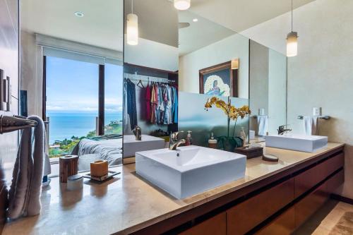 une salle de bain avec deux lavabos et un grand miroir dans l'établissement Oceanview Oasis in La Cruz, à La Cruz de Huanacaxtle