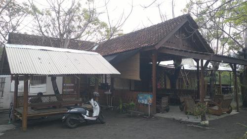 una casa con una moto aparcada frente a ella en Omah mak isun pulau santen, en Banyuwangi