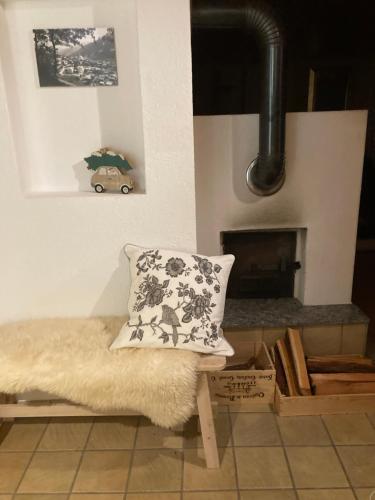 ein Kissen auf einer Bank vor einem Kamin in der Unterkunft Römerhaus in Münster VS