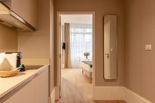 a kitchen with a sink and a mirror at La Maison Blanche - AppartHôtels de charme Chic & Cosy à 350m du cœur de ville de Limoges - Accès autonome in Limoges