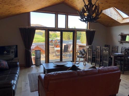 a living room with a couch and a table at Lochside Lodge in White Bridge