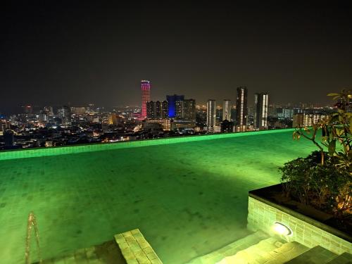 een zwembad op het dak met 's nachts een skyline van de stad bij SkyPool 2BR 9pax Premium Suite@Beacon @Georgetown @Penang in George Town