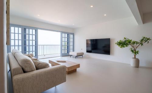 uma sala de estar com um sofá e uma televisão em Waterside Apartments em Willemstad