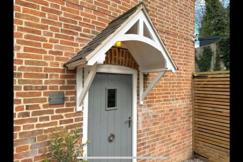 una puerta blanca con un arco sobre un edificio de ladrillo en Honeysuckle Cottage, en Mountsorrel