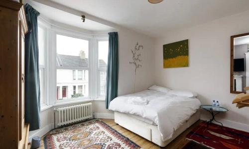 a small bedroom with a bed and a window at Three Bedroomed Victorian Family House, Garden in Brighton & Hove