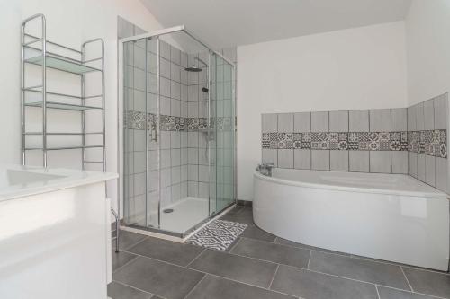 a bathroom with a tub and a glass shower at Le Grand Pressoir - Grande maison avec jardin in Nanton