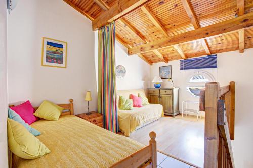 une chambre avec un lit et un canapé dans l'établissement Maisonnette du Clos - Avec piscine partagée, à Argelès-sur-Mer