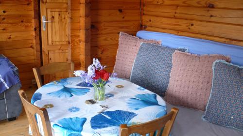 Clais的住宿－Chalet à la campagne，一张桌子和椅子,上面有花瓶