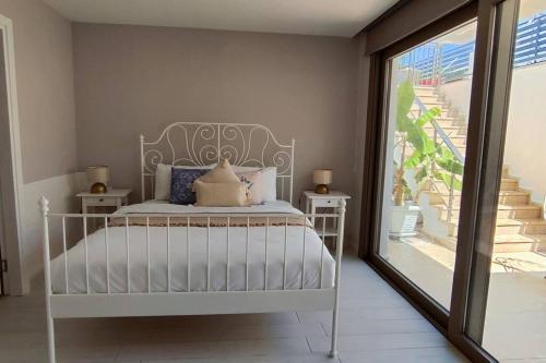 a bedroom with a white bed and a balcony at Bodrum merkez'de Havuzlu, Saunalı, müstakil villa in Bodrum City