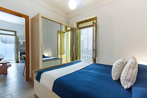 トッレ・カンネにあるAppartamento Venere - MyHo Casaのベッドルーム(青いベッド1台、バルコニー付)