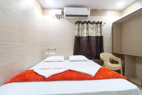 a bedroom with a bed with a red blanket at HOTEL VALLABHA RESIDENSY in Rājahmundry