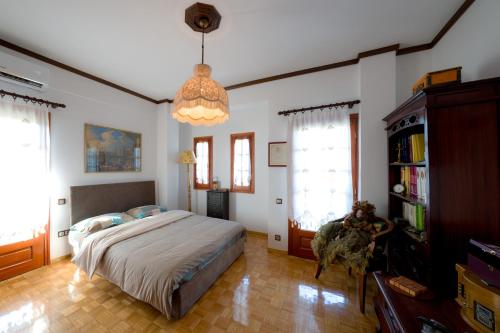 a bedroom with a bed and a chandelier at Archontiko Alexandros Luxury Suites in Kardiá