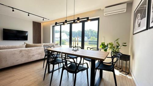 jadalnia i salon ze stołem i krzesłami w obiekcie Apartamenty Parkowa - Kamień Śląski w mieście Kamień Śląski