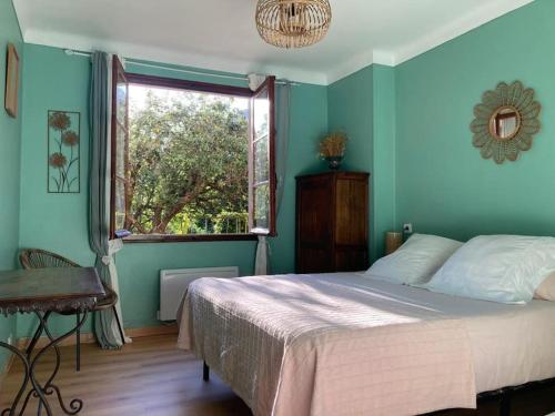 a bedroom with blue walls and a bed with a window at Charmant T2 dans chalet familial in Valdeblore