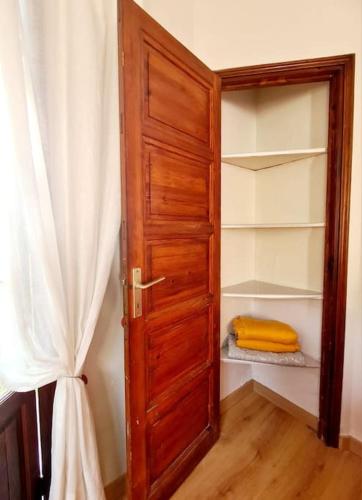 a closet with an open wooden door with a towel at Charmant T2 dans chalet familial in Valdeblore