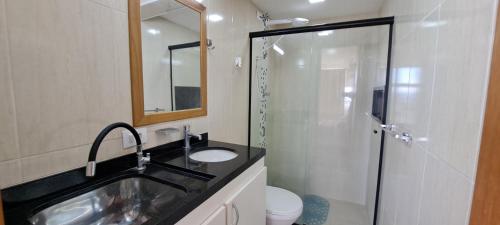 een badkamer met een wastafel en een glazen douche bij Centro de SP, vista p/ ZN in Sao Paulo