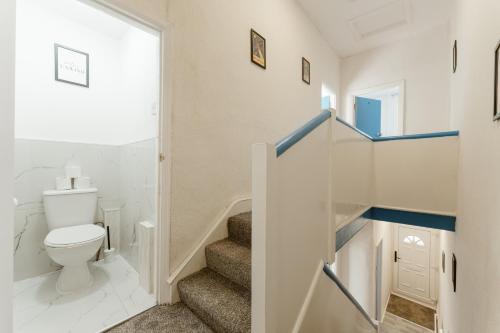 a bathroom with a toilet and a staircase at Leyton Comfy Double rooms -50 in London