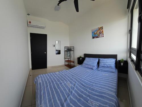 - une chambre avec un lit et une couette bleue dans l'établissement Sky Garden Homestay, Presint 15 Putrajaya, à Putrajaya
