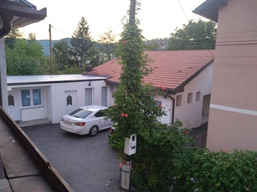 ein Auto, das auf einem Parkplatz vor einem Haus parkt in der Unterkunft Apartmani Milica in Banja Luka
