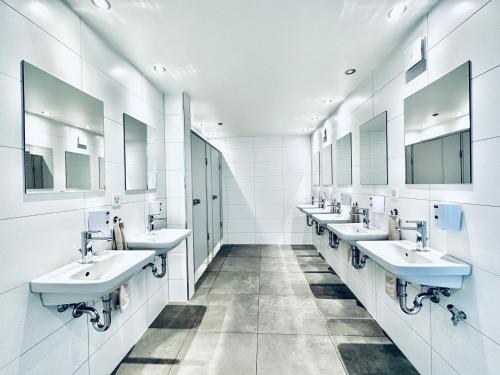 a bathroom with a row of sinks and mirrors at Monteurzimmer ZIMMERzuVERMIETEN in Bäriswil in Bäriswil
