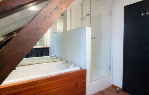 une salle de bain avec une baignoire blanche et une douche dans l'établissement Refuge centre ville avec parking, à Annecy