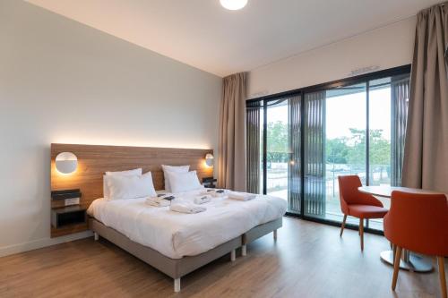 pokój hotelowy z łóżkiem, stołem i krzesłami w obiekcie Villa Thermae Nancy w Nancy