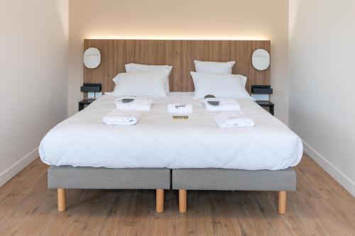 a bedroom with a large bed with two towels on it at Villa Thermae Nancy in Nancy