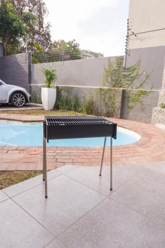 a black piano sitting on a sidewalk next to a pool at Hampton Collection - Contemporary 3 Sleeper Apartment with Pool in Durban