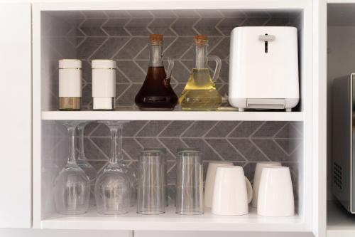 a cabinet filled with bottles and containers of wine at Hampton Collection - Contemporary 3 Sleeper Apartment with Pool in Durban